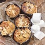 Fem muffins med s'mores-smak och marshmallows på en pappersbit.