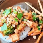 Vegetarisk Pad Thai med Quorn, broccoli, jordnötter och ris på en tallrik med ätpinnar.