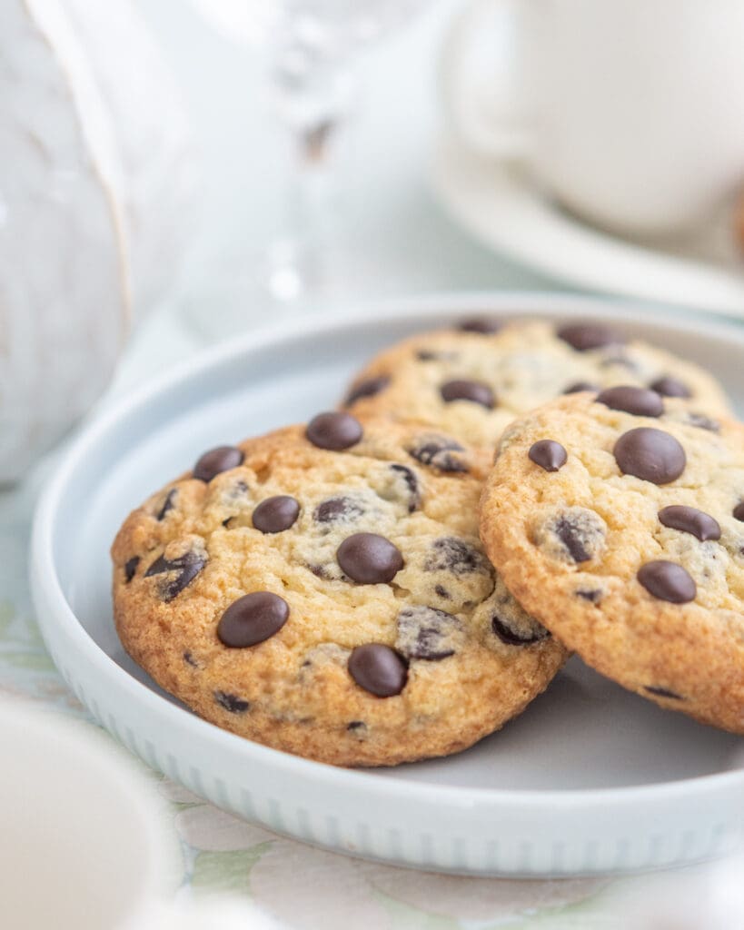 Glutenfria kolakakor 9 Tre chokladchipkakor med mörka chokladbitar på en ljus tallrik.