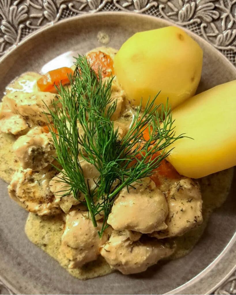 Citronkyckling 7 En tallrik med dillkyckling, potatis och morötter, dekorerad med färsk dill.