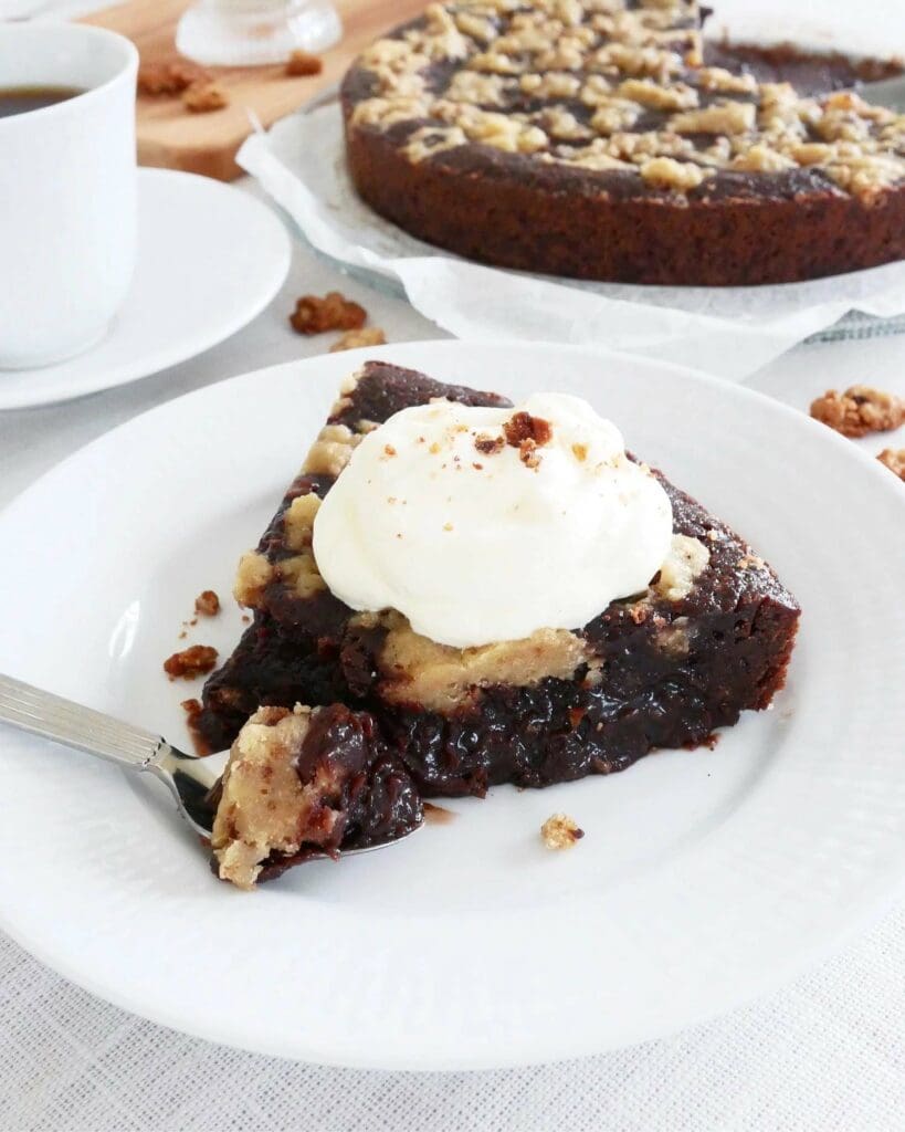 Världens godaste kladdkaksmuffins 11 En bit kladdkaka med cookie dough och grädde på en vit tallrik med gaffel.