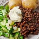 Tallrik med kryddig köttfärs, kokt potatis, grönsaker och sås.