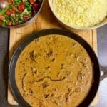 En gryta med lövbiff och champinjoner i en krämig sås, serverad med ris och grönsallad.
