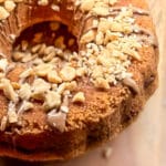 En sockerkaka med nougat och hackade nötter på toppen, placerad på en träyta.