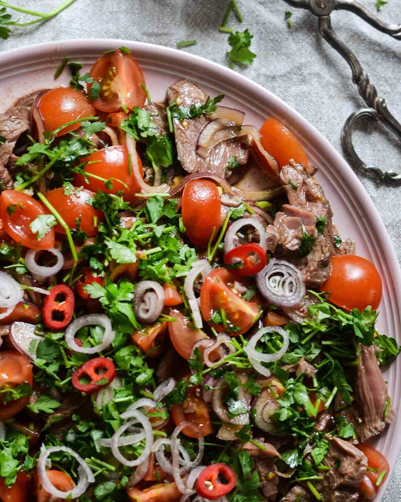 Het köttsallad med chili, rödlök och körsbärstomater Het köttsallad med chili, rödlök och körsbärstomater