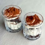 Två glas med kladdkakedessert som har tiramisufyllning och ett lager kakao på toppen.
