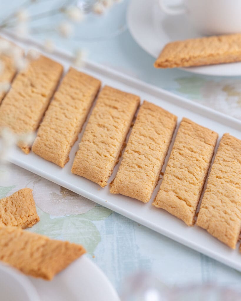 Glutenfria kolakakor 7 En rad med kola kakor på ett vitt fat, med några kakor delade i bitar.