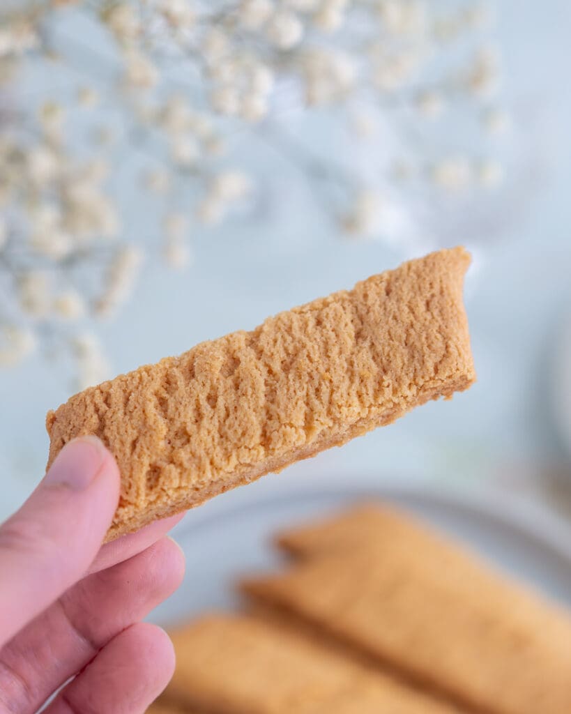 Glutenfria kolakakor 8 En person håller en bit kola kaka med en struktur av kex i handen.
