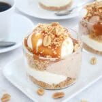 Nougatcheesecake serverad i glas med jordnötter och karamellsås på toppen.