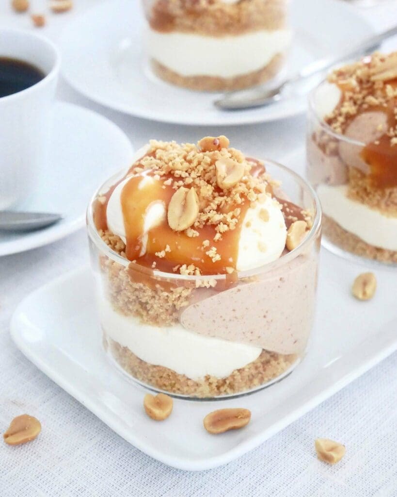 Fryst vaniljcheesecake med passionsfrukt 12 Nougatcheesecake serverad i glas med jordnötter och karamellsås på toppen.