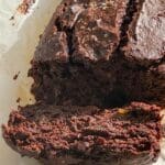 En skiva av en chokladbrownie med nötter, delad på en bakplåt.