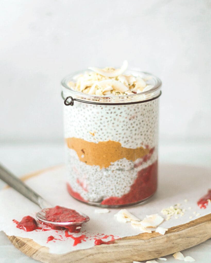 3 smarta recept med keso 11 En glasburk med chiapudding lager av jordnötssmör och hallon, toppad med kokosflingor.