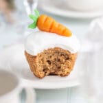 Morotsmuffins med vit glasyr och en sockerformad morot på toppen.