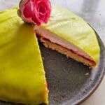Prinsesskladdkaka med grön marsipan och en ros på toppen, skuren i en bit.