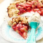 En skiva rabarbergalette på en tallrik med en skopa glass bredvid.