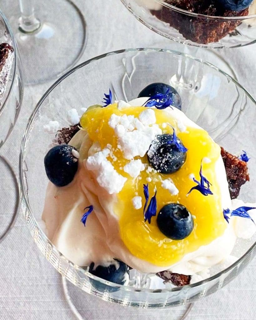 Lättlagad påskdessert i glas 6 Dessert i glas med grädde, blåbär, citronsås och ätbara blommor.