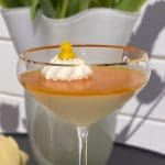 Passionsfruktspannacotta med grädde och dekoration i ett glas.