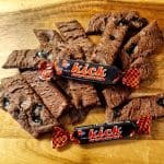 Chokladsnittar med lakrits och två Kick godisar på en träyta.