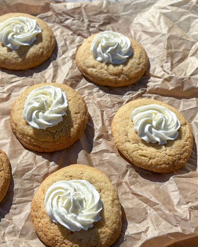 Cookies med lemon curd 14 Sex kakor med gräddfrosting placerade på ett brunt papper.