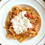 Tallrik med pasta, salsicca och ricotta, toppad med svartpeppar.