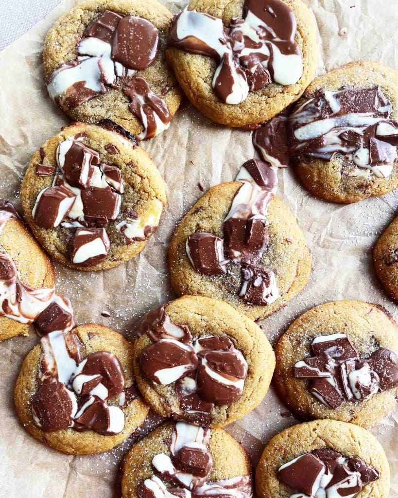 Pistagecookies 9 En samling av nybakade kakor med stora chokladbitar och smält choklad på toppen.