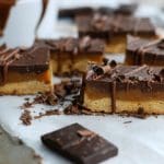 Skivor av en dessert med choklad, kola och kex, dekorerade med chokladspån.