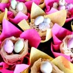 Muffins dekorerade med färgglada papper och chokladägg i olika färger.