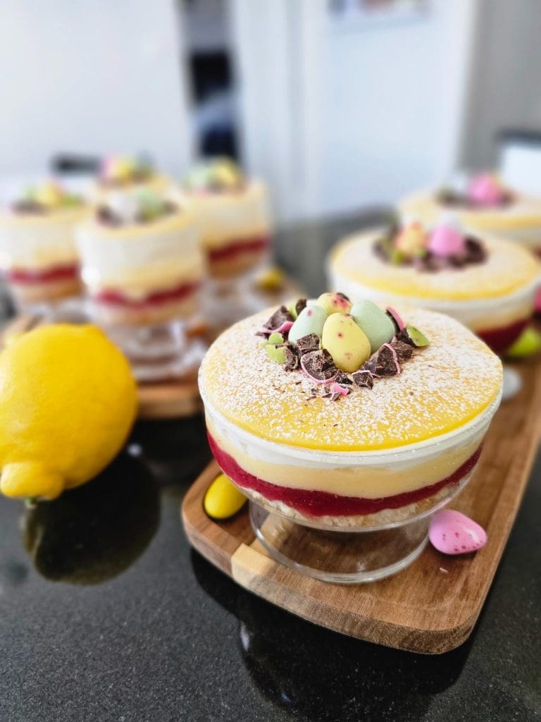 Påskprinsesstårta i glas med lemon curd 10 Paskprinsesstårta i glas med lager av grädde, sylt och dekorationer av godis och nötter.