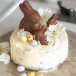 En påsktårta dekorerad med chokladkaniner och färgglada godisägg.