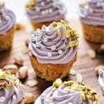 Cupcakes med lila frosting, dekorerade med pistagenötter och silverkulor.