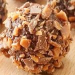 Chokladboll rullad i krossad daim, med en jämn yta och bitar av choklad och nötter.