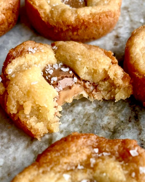 Kolakakor med inbakad choklad 9 Bakade kolakakor med Dumle inuti, med en bit av kakan som är avskuren.