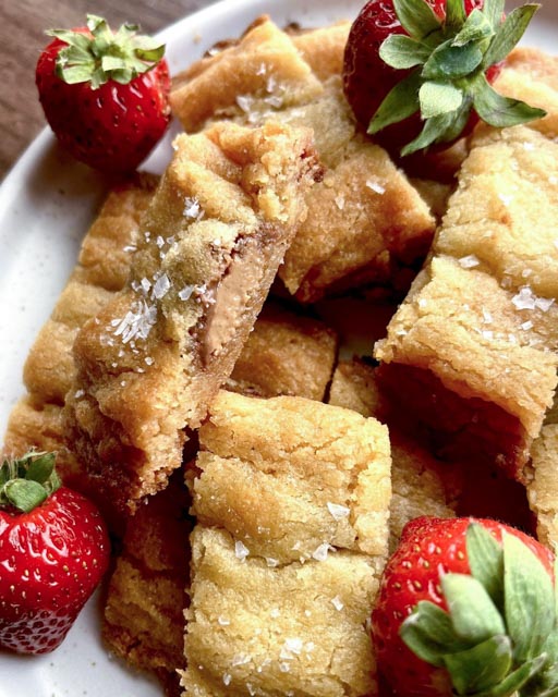 Nutellabrookie 7 Kolasnittar med inbakad nougat på en tallrik, dekorerad med färska jordgubbar.