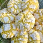 En tallrik med lemoncrackles kakor, gula med vit pudersocker på toppen.