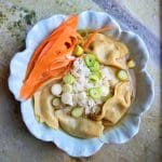 Skål med ris, dumplings och strimlad morot på en marmor yta.