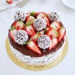 Chokladbollstårta dekorerad med jordgubbar och kokosbollar på toppen.