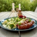 Tallrik med ortstuvad potatis och isterband, garnerad med dill och persilja.