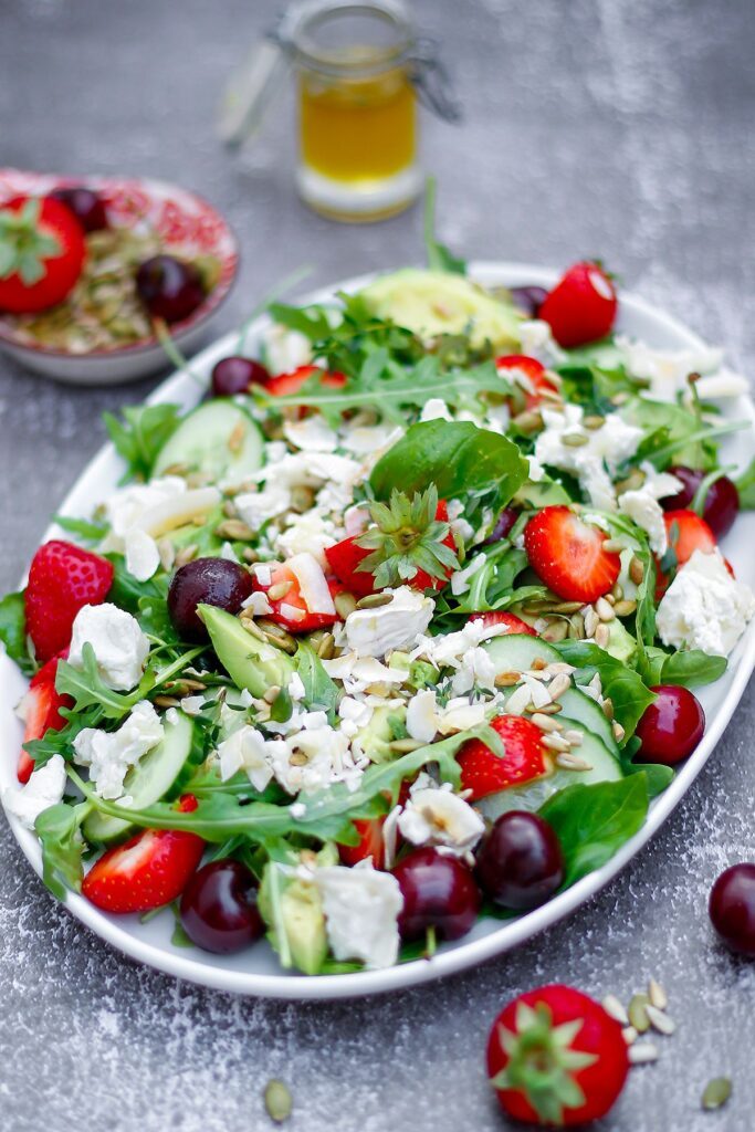 Pastasallad med kyckling 10 En tallrik med sommarsallad innehållande ruccola, körsbär, jordgubbar och chèvre.