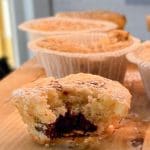 Tigermuffin med chokladfyllning som har en bit tagen ur den. Muffins i bakgrund.