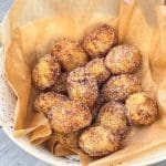 En skål med gnocchi churrosi som är täckta med socker och kanel.