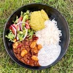 En skål med chili con carne, ris, guacamole och grönsallad.