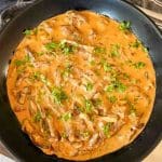 En krämig pastasås med lövbiff, champinjoner och grön persilja i en stekpanna.