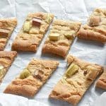 Bakade rabarbersnittar skurna i bitar och placerade på ett vitt bakplåtspapper.